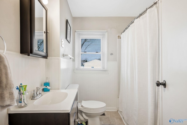 bathroom featuring vanity, tile patterned flooring, and toilet