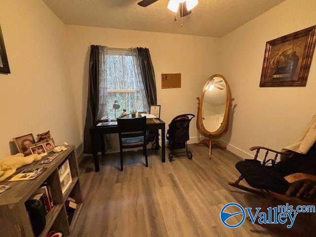 office with a textured ceiling, ceiling fan, wood finished floors, and baseboards