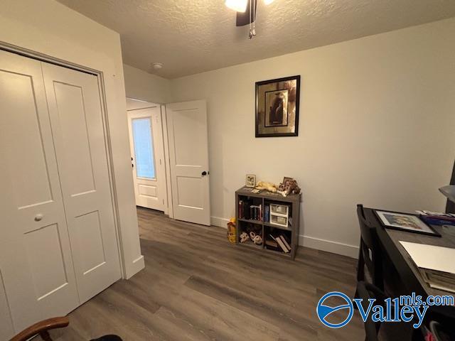 office space with a textured ceiling, baseboards, and dark wood-style flooring