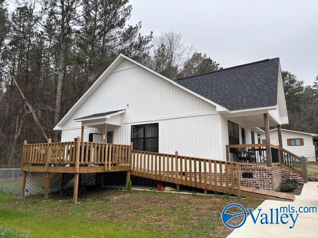 back of property featuring a deck and roof with shingles