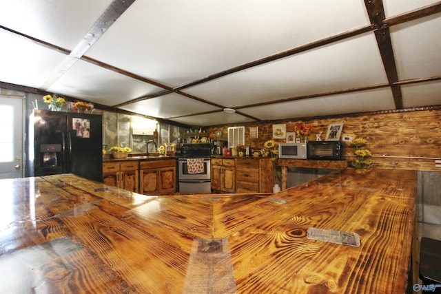 kitchen featuring a sink, black appliances, brown cabinets, and butcher block countertops