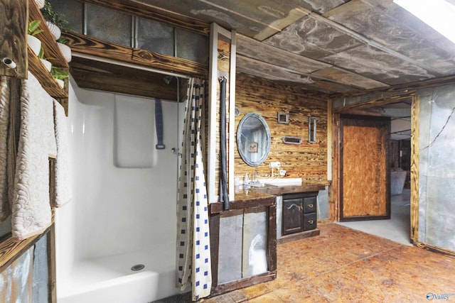 interior space with vanity, wooden walls, and a stall shower