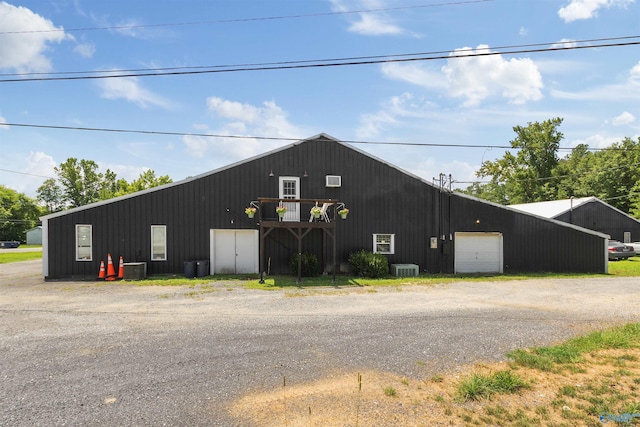 view of pole building with central air condition unit and driveway