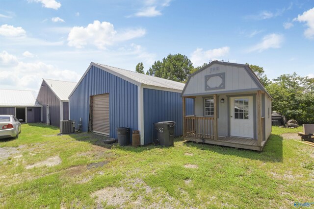 view of outbuilding with cooling unit, an outbuilding, and driveway