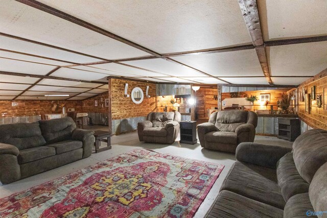 living room featuring wood walls, concrete floors, and a textured ceiling