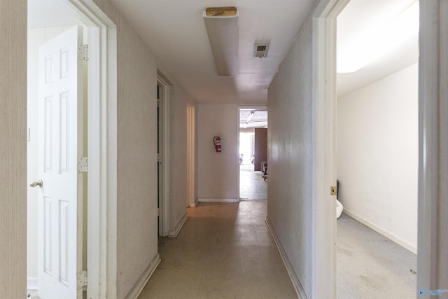 hallway featuring baseboards and visible vents