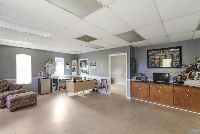 interior space featuring light floors and a paneled ceiling