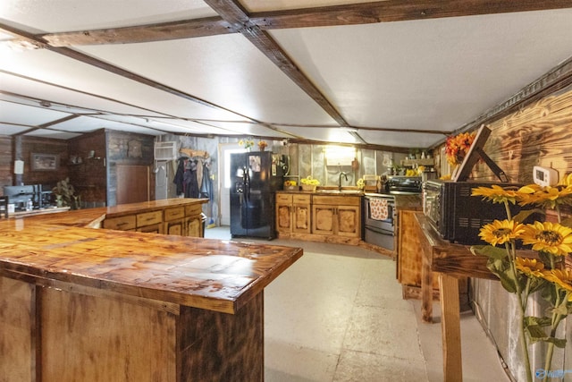 kitchen featuring wooden counters, brown cabinets, a peninsula, black appliances, and a sink