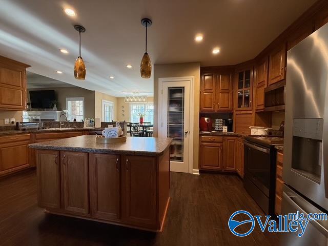 kitchen with dark countertops, pendant lighting, recessed lighting, appliances with stainless steel finishes, and dark wood-style floors