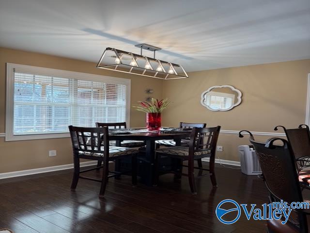 dining area featuring dark wood-type flooring and baseboards