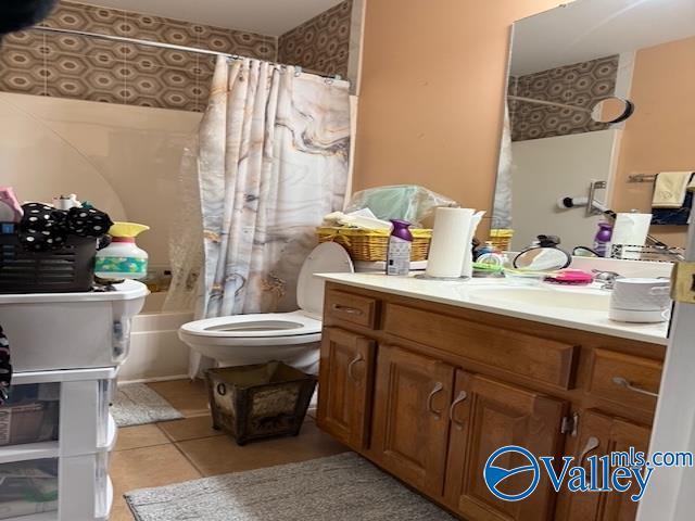 full bathroom featuring toilet, vanity, and tile patterned flooring