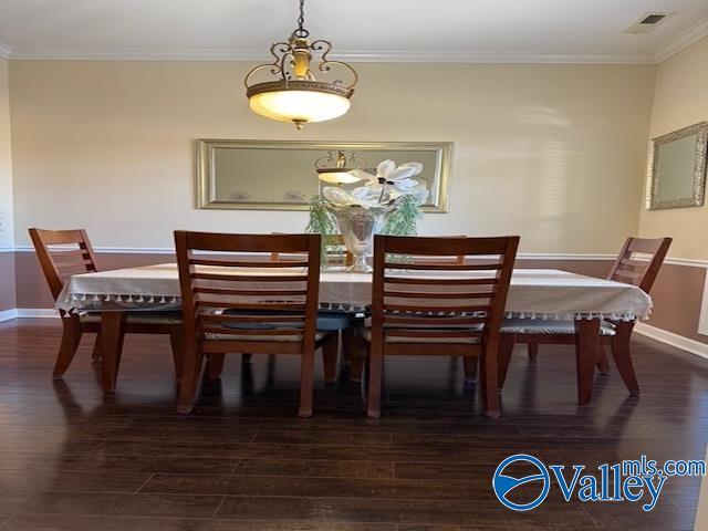 dining space with visible vents, baseboards, dark wood finished floors, and crown molding