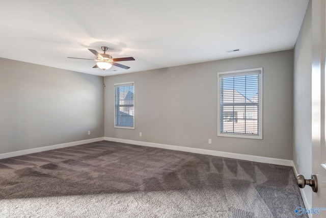 carpeted spare room featuring plenty of natural light and ceiling fan