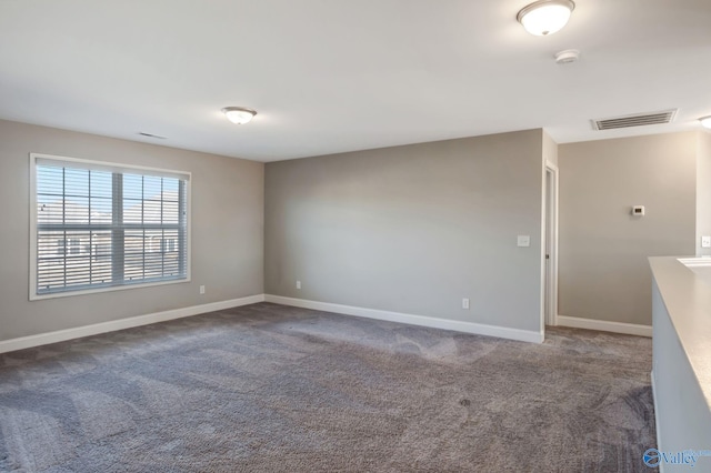 spare room with dark colored carpet