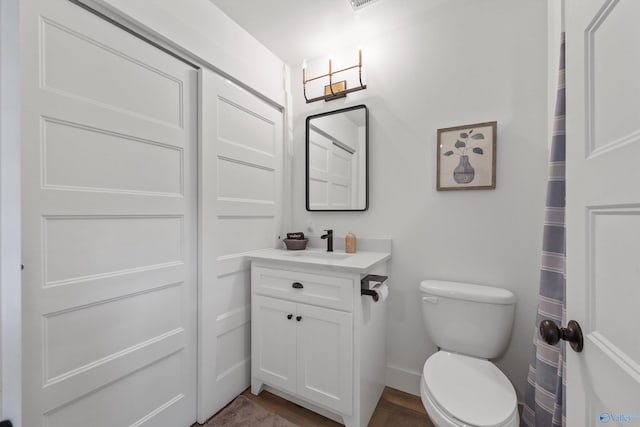 bathroom with hardwood / wood-style floors, vanity, and toilet