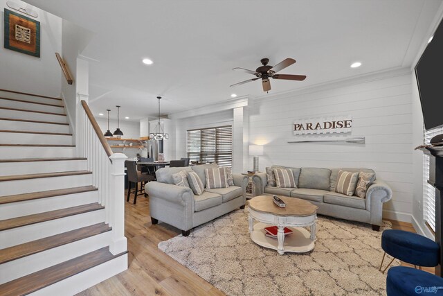 living room featuring ceiling fan, light hardwood / wood-style floors, and ornamental molding