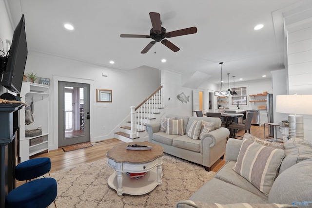 living room featuring ceiling fan, light wood-type flooring, and ornamental molding