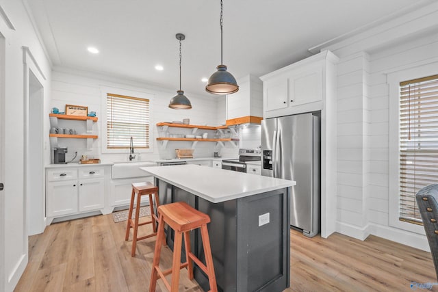 kitchen featuring white cabinetry, sink, a center island, stainless steel appliances, and light hardwood / wood-style flooring