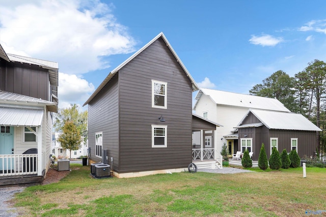 back of house featuring central AC unit and a yard