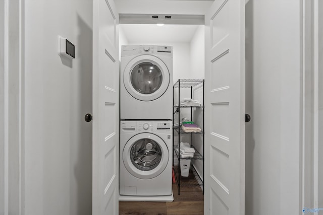 laundry area with stacked washer and dryer and dark wood-type flooring