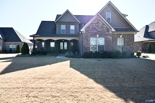 craftsman house with a front lawn and brick siding