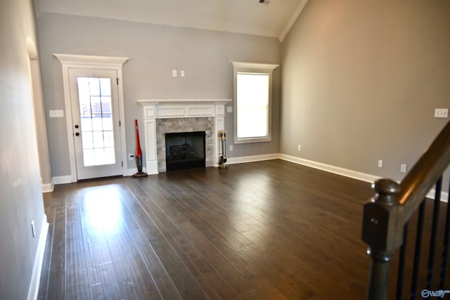 unfurnished living room with a healthy amount of sunlight, a fireplace, vaulted ceiling, and dark wood-type flooring