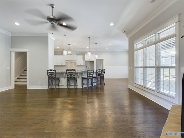 interior space featuring white cabinets, pendant lighting, a breakfast bar area, and a wealth of natural light