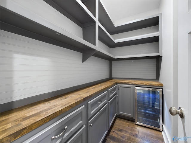 bar with gray cabinetry, dark hardwood / wood-style floors, wine cooler, and wooden counters