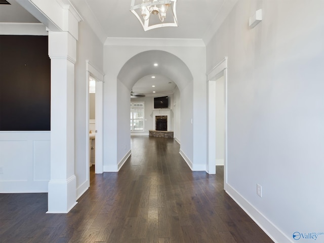 hall with a chandelier, dark hardwood / wood-style floors, and crown molding