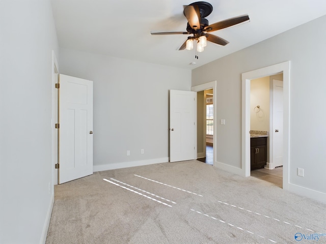 unfurnished bedroom featuring light carpet, ensuite bath, and ceiling fan