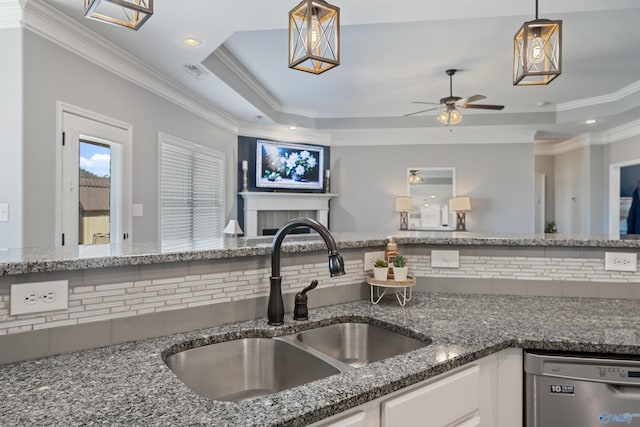 kitchen featuring dishwasher, open floor plan, a sink, and a raised ceiling