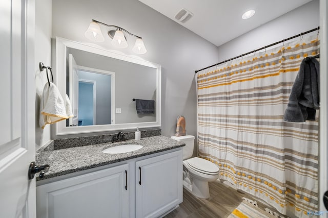 bathroom with a shower with shower curtain, visible vents, toilet, and vanity