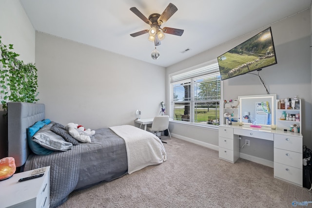 bedroom featuring light colored carpet, baseboards, a ceiling fan, and visible vents