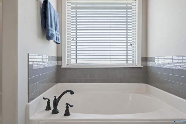full bathroom featuring a garden tub and a wealth of natural light