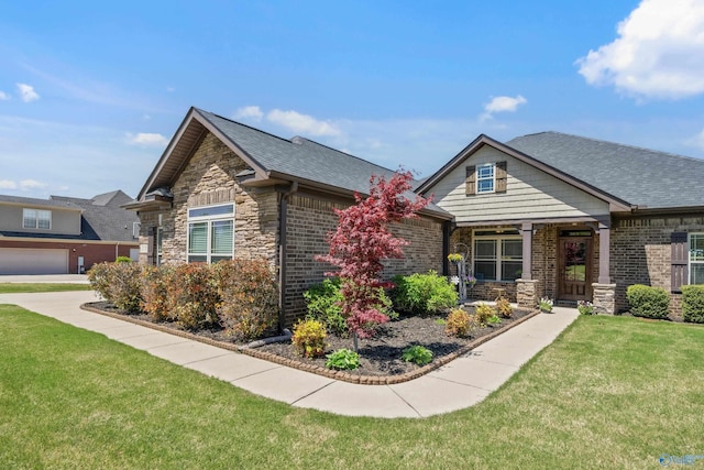 craftsman inspired home with roof with shingles, stone siding, and a front yard