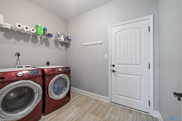 washroom featuring separate washer and dryer, baseboards, and laundry area