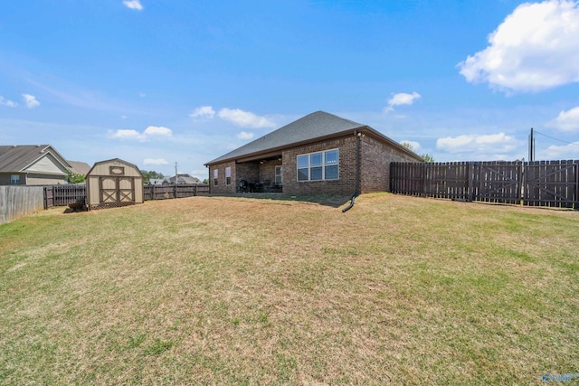 view of yard with an outdoor structure, a shed, and a fenced backyard