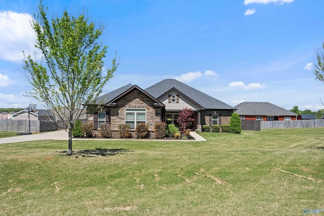 craftsman inspired home with fence, stone siding, and a front yard