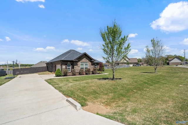 view of front of home featuring a front lawn, stone siding, concrete driveway, fence, and a garage