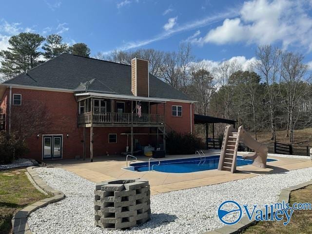 752 12th Way NE, Arab, AL 35016 - back of house with a chimney, a wooden deck, a patio area, stairs, and an outdoor pool