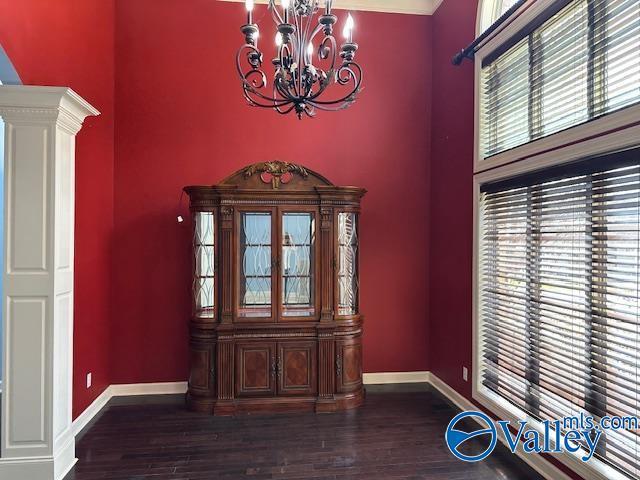 752 12th Way NE, Arab, AL 35016 - unfurnished dining area featuring baseboards, wood finished floors, a high ceiling, and an inviting chandelier