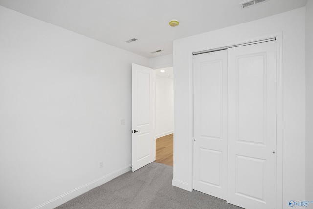 unfurnished bedroom featuring a closet and light carpet