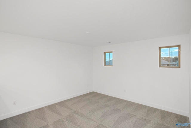 empty room featuring plenty of natural light and light carpet