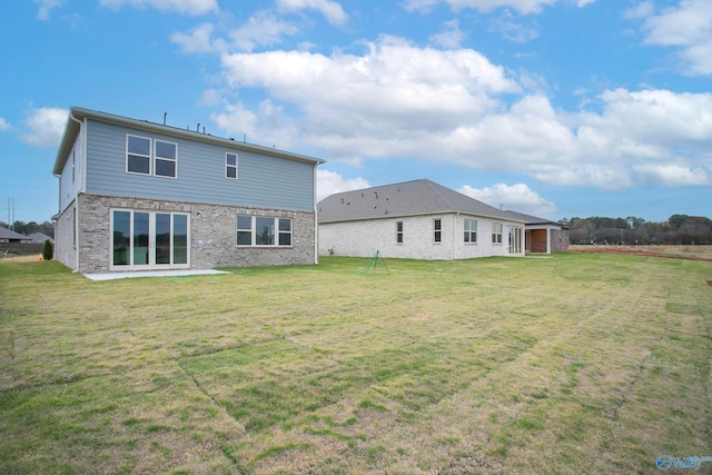 rear view of property featuring a patio area and a lawn