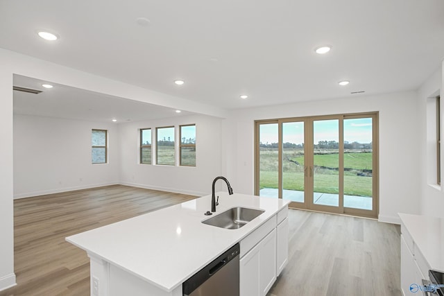 kitchen with dishwasher, sink, white cabinets, a kitchen island with sink, and light hardwood / wood-style floors