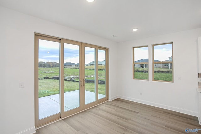 entryway with a wealth of natural light, french doors, and light wood-type flooring