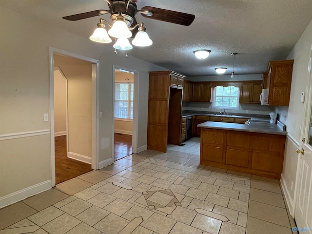 kitchen featuring kitchen peninsula, a textured ceiling, stove, light tile patterned floors, and ceiling fan