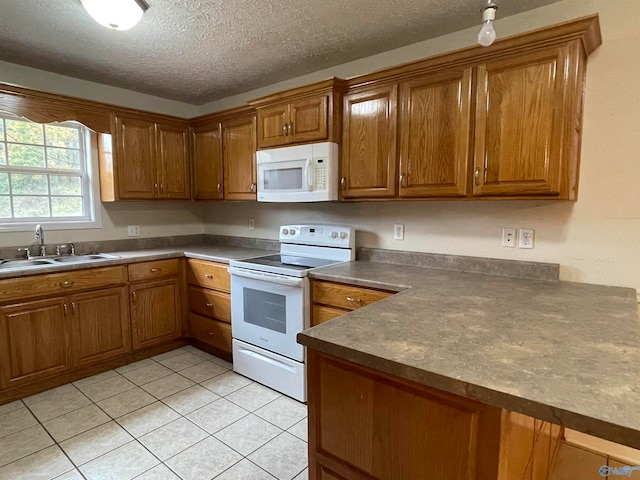 kitchen with light tile patterned floors, white appliances, a textured ceiling, and sink