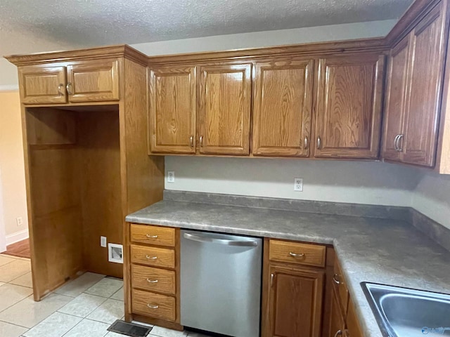 kitchen with dishwasher, a textured ceiling, and light tile patterned floors