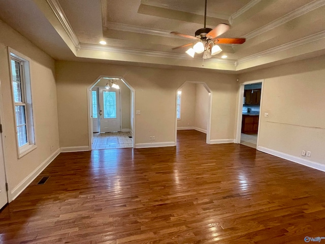 spare room with dark hardwood / wood-style flooring and a raised ceiling